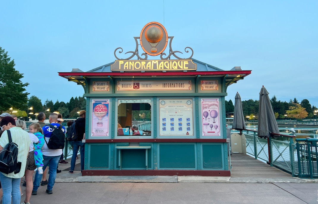 PanoraMagique ticket booth at Disney Village, Disneyland Paris, with visitors in line.