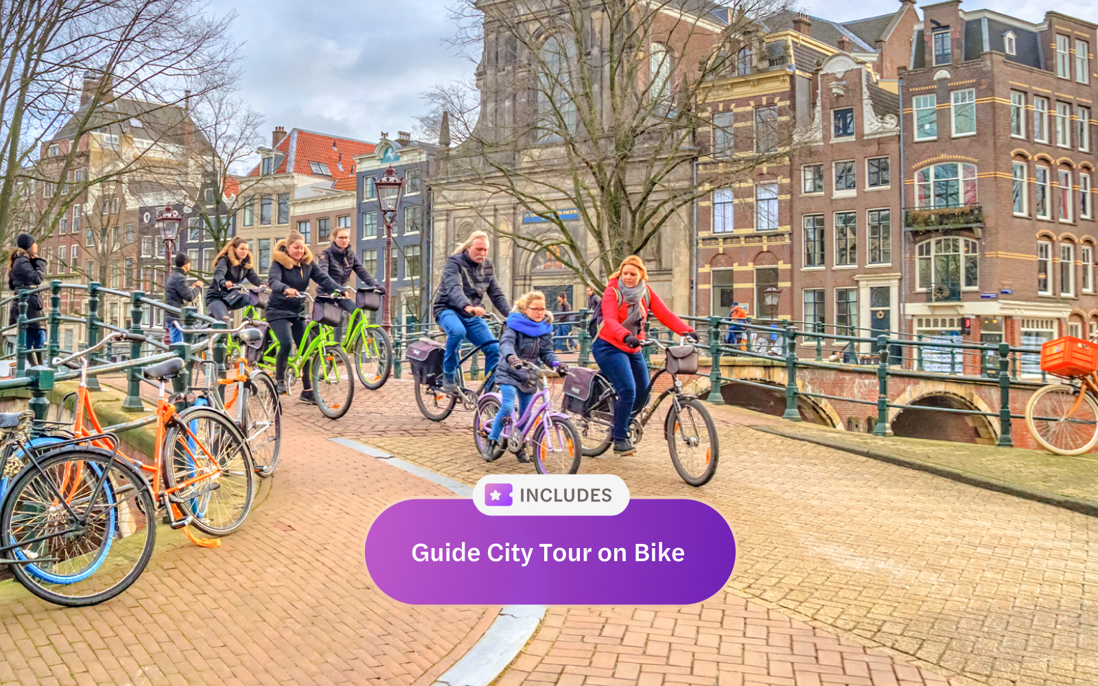 Cyclists on a guided tour crossing an Amsterdam canal bridge.