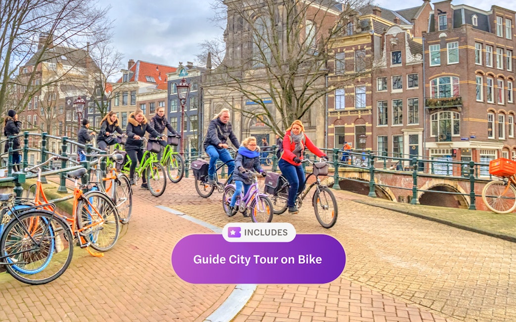 Cyclists on a guided tour crossing an Amsterdam canal bridge.