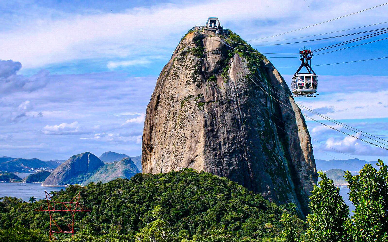 Sugarloaf Mountain cable car ascending with scenic Rio de Janeiro landscape.