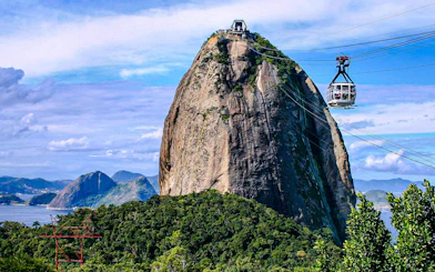 Sugarloaf Mountain cable car ascending with scenic Rio de Janeiro landscape.