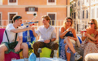 Group of friends enjoying drinks on a terrace in Rome.