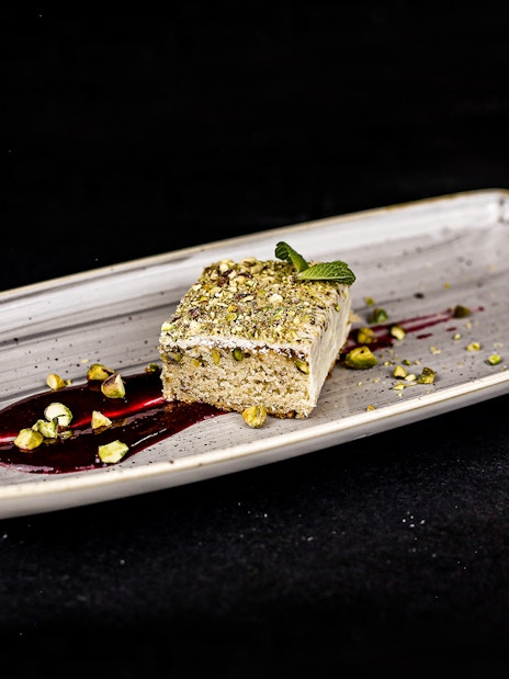 White chocolate lemon-pistachio sponge cake on Budapest Dinner Cruise plate.