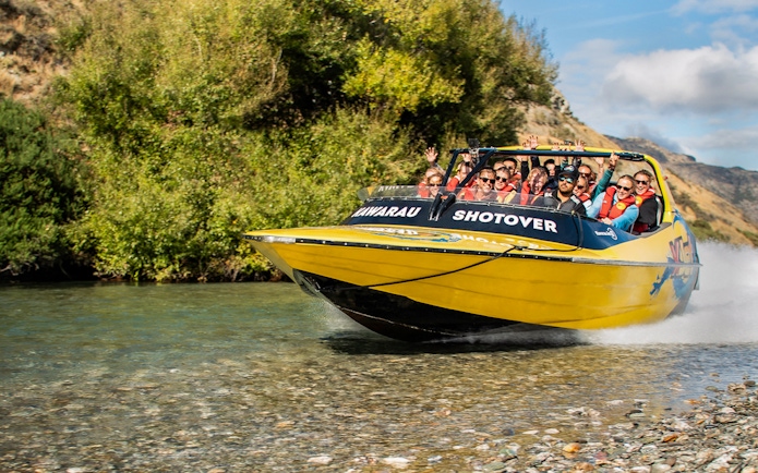 Jet boat on Kawarau and Shotover Rivers with mountains in the background.