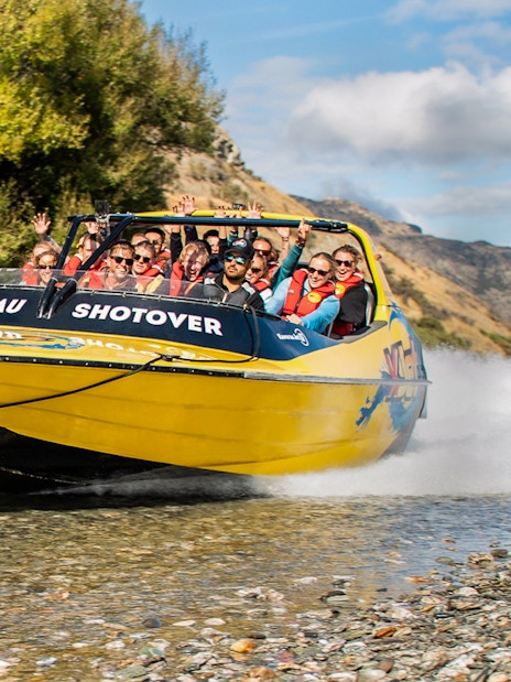 Jet boat on Kawarau and Shotover Rivers with mountains in the background.