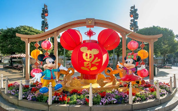 Mickey Mouse greeting visitors at Disneyland Hong Kong entrance.