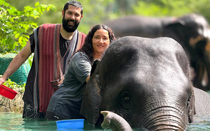 Couple bathing elephant at Phuket Elephant Care Sanctuary.