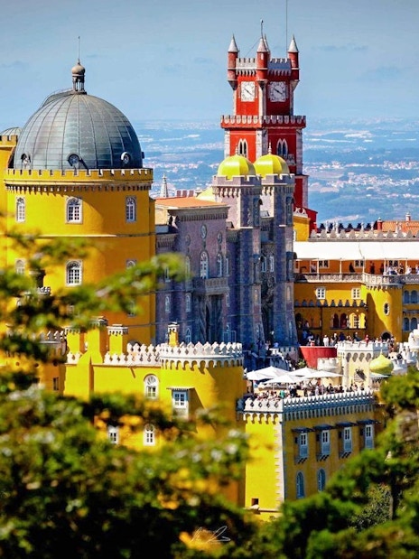 Pena Palace in Sintra, Portugal, with vibrant yellow and red towers.