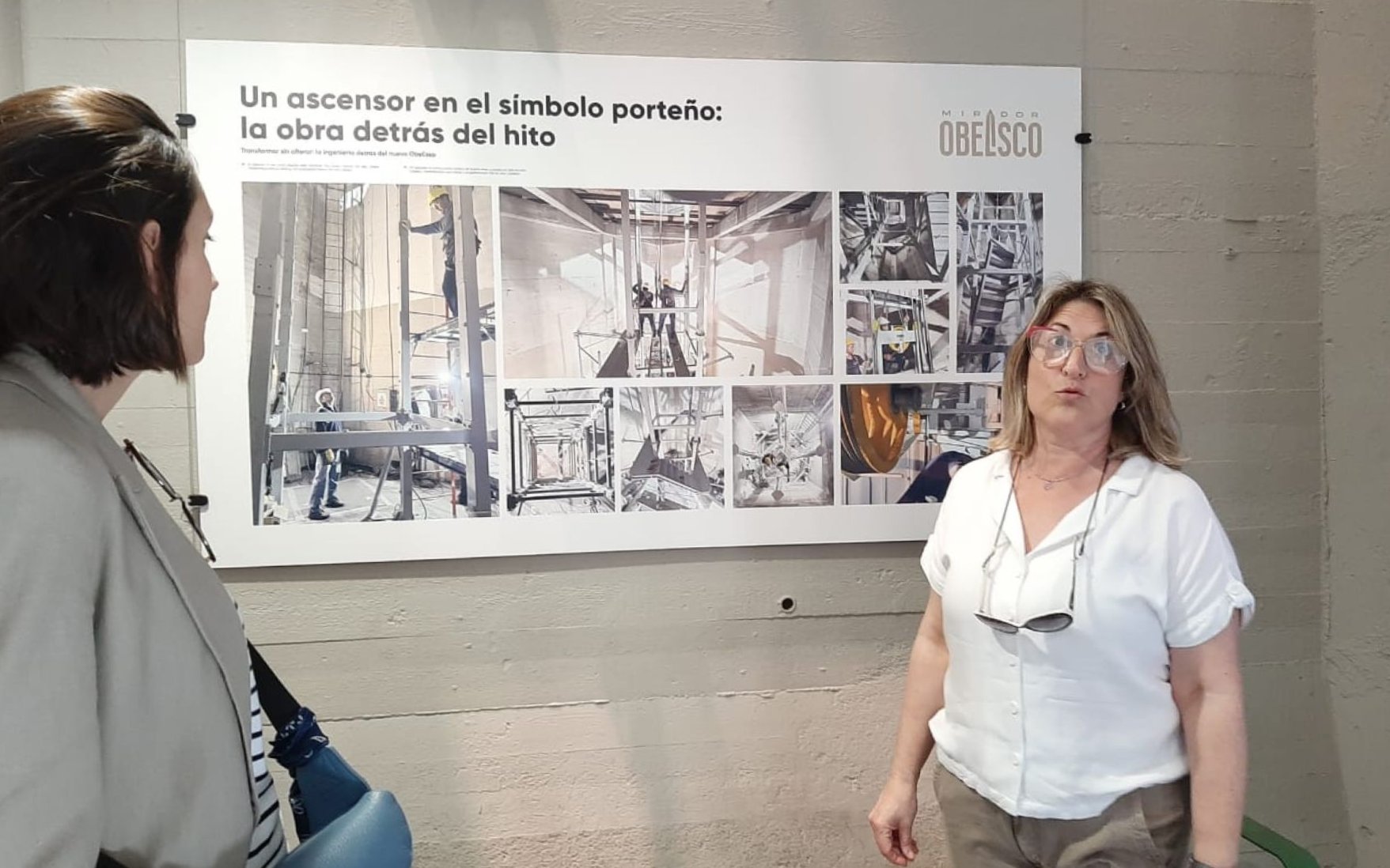 Tourist with guide discussing exhibit at Obelisco de Buenos Aires.
