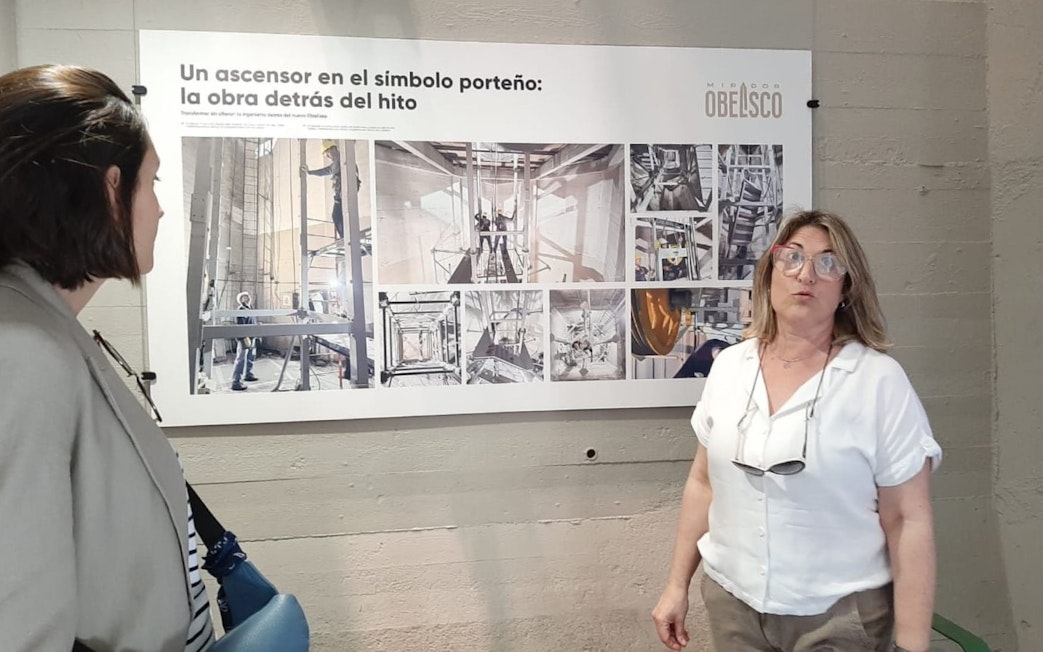 Tourist with guide discussing exhibit at Obelisco de Buenos Aires.