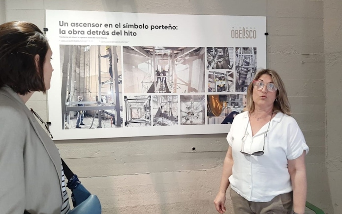 Tourist with guide discussing exhibit at Obelisco de Buenos Aires.