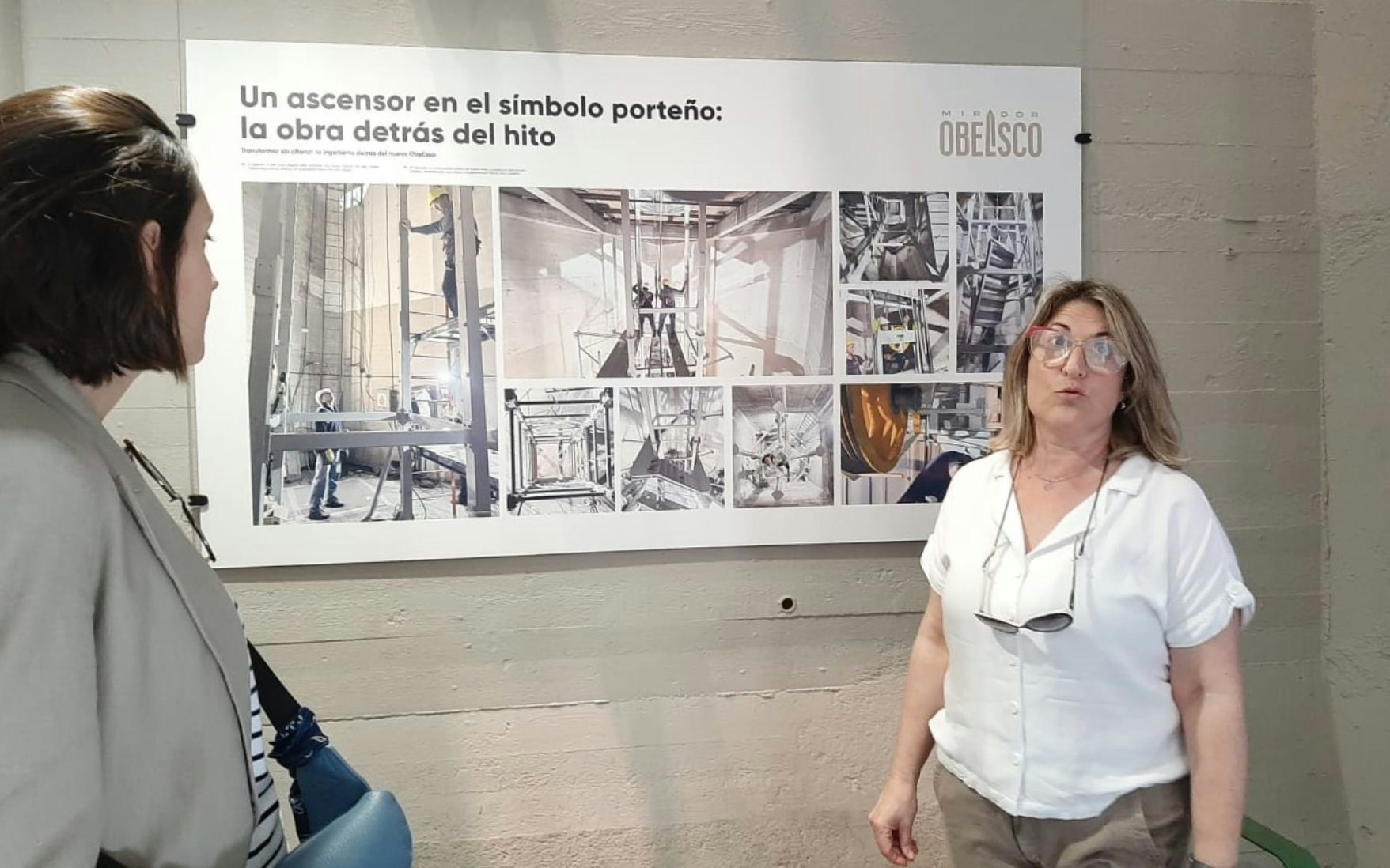 Tourist with guide discussing exhibit at Obelisco de Buenos Aires.