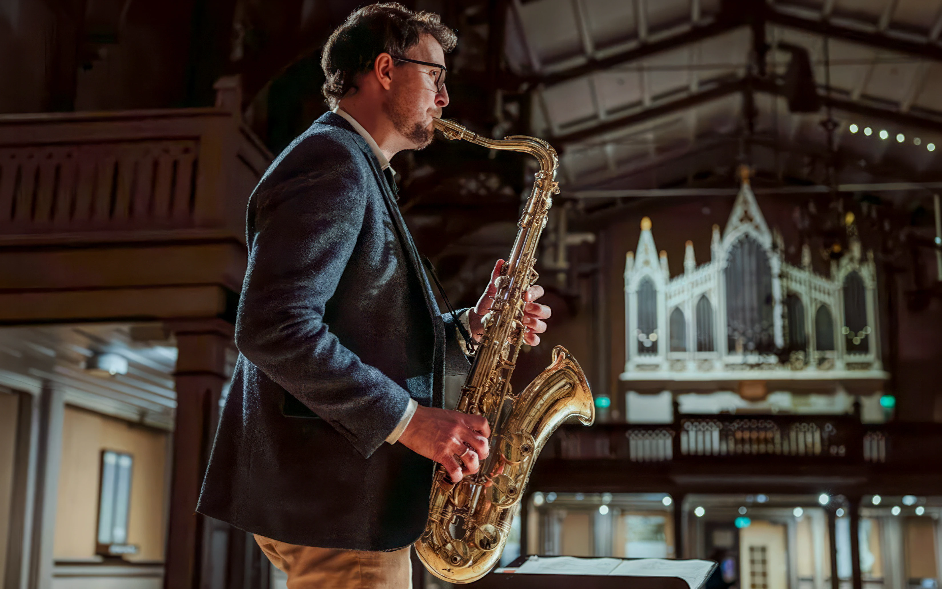 Performer playing saxophone at midnight concert inside Tromso Cathedral.