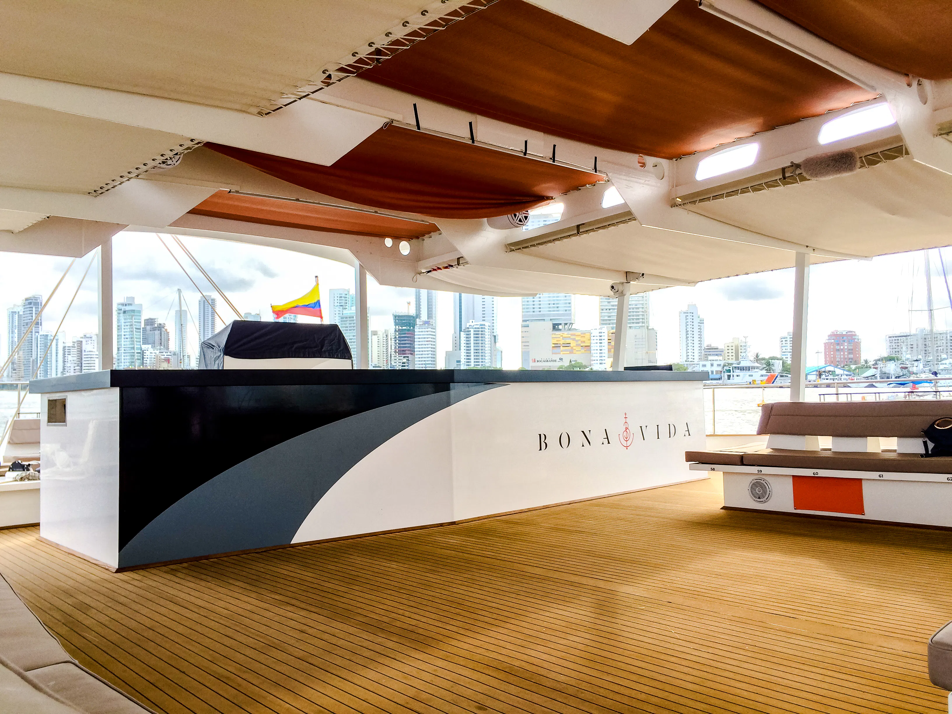 Catamaran deck with open bar and city skyline view in Cartagena.