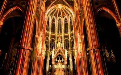 Votivkirche interior illuminated during Light of Creation event in Vienna.