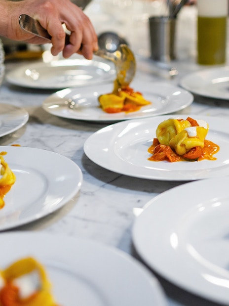 Freshly made fettuccine being plated at a Rome cooking class.