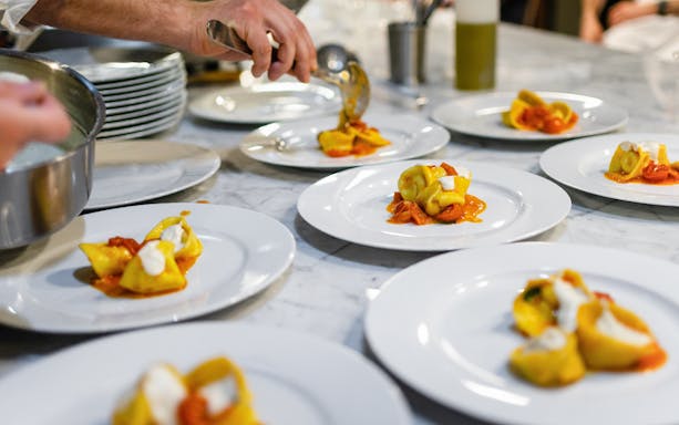 Freshly made fettuccine being plated at a Rome cooking class.