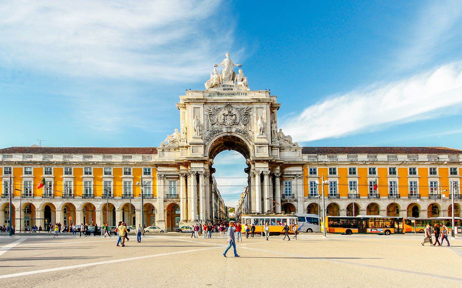 Praca do Comercio arch in Lisbon with people and tram in foreground.