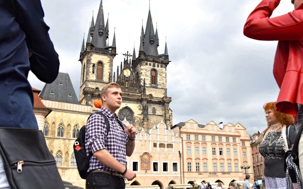 Tour guide leading a group in front of Prague's Church of Our Lady before Týn.
