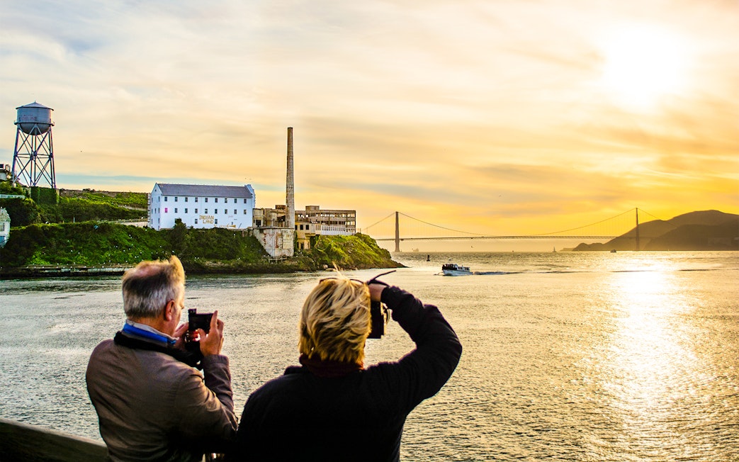 Guests photographing sunset near Alcatraz Island during California Sunset cruise.