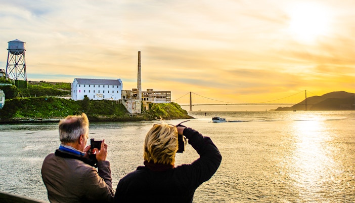 Guests photographing sunset near Alcatraz Island during California Sunset cruise.