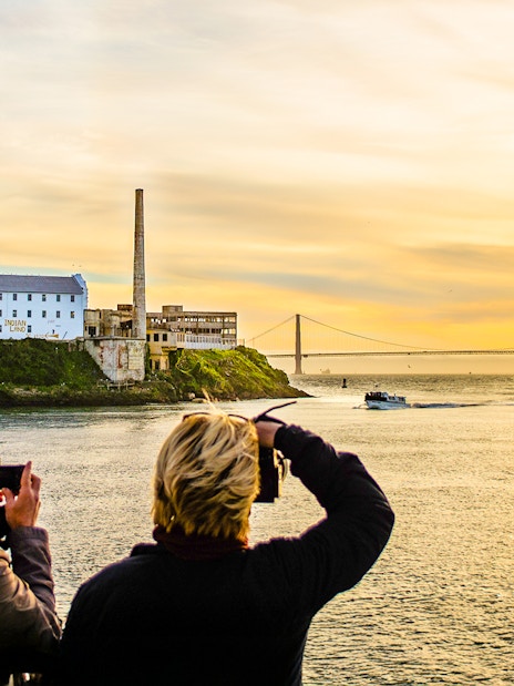 Guests photographing sunset near Alcatraz Island during California Sunset cruise.