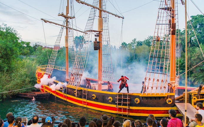 Pirate ship performance at Isla Magica with actors in costume and audience watching.