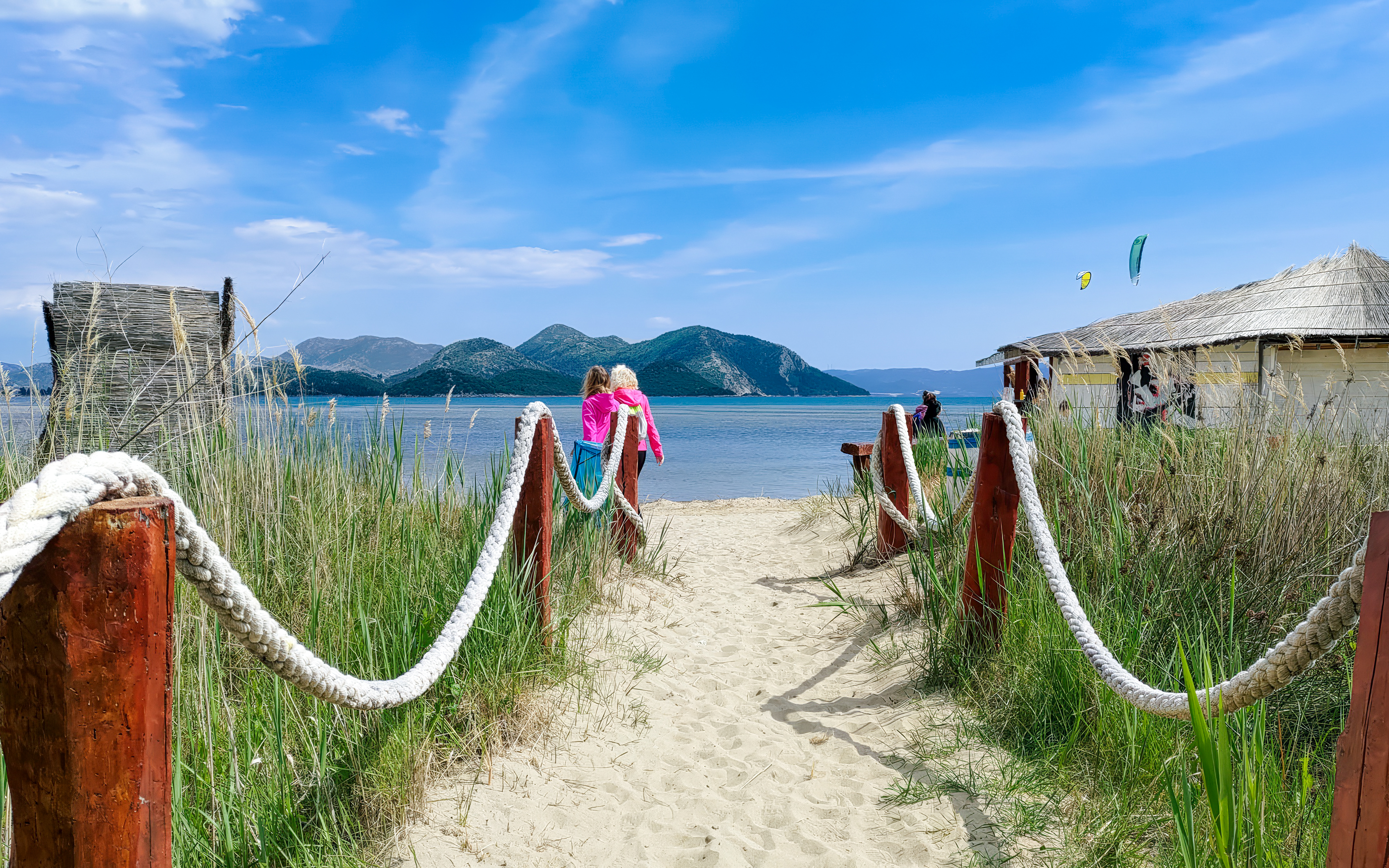 Pathway leading to the beach with mountains in the background, Delta Neretva, Croatia.