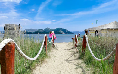 Pathway leading to the beach with mountains in the background, Delta Neretva, Croatia.
