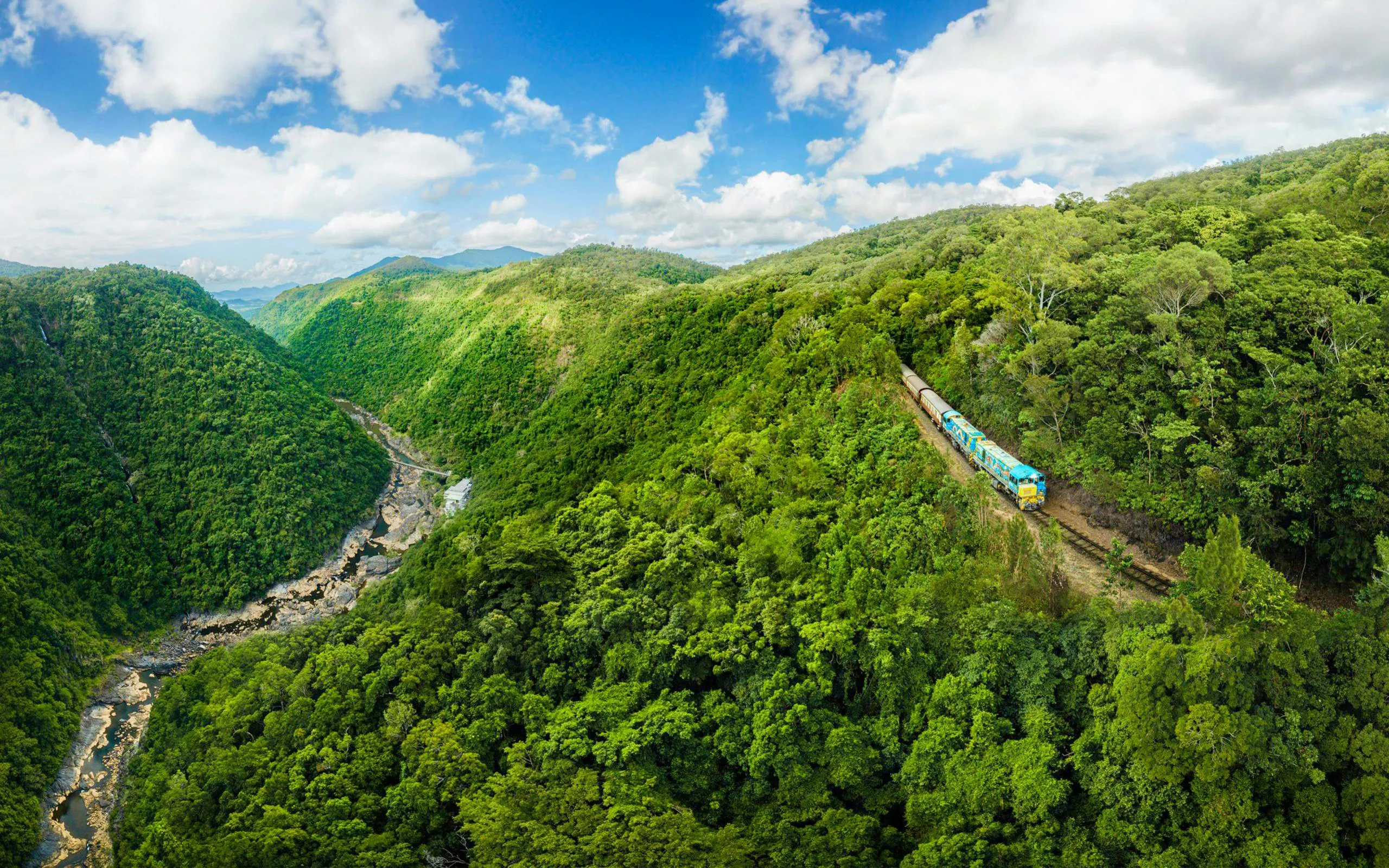 Kuranda Scenic Rail passing through lush rainforest in Queensland, Australia.