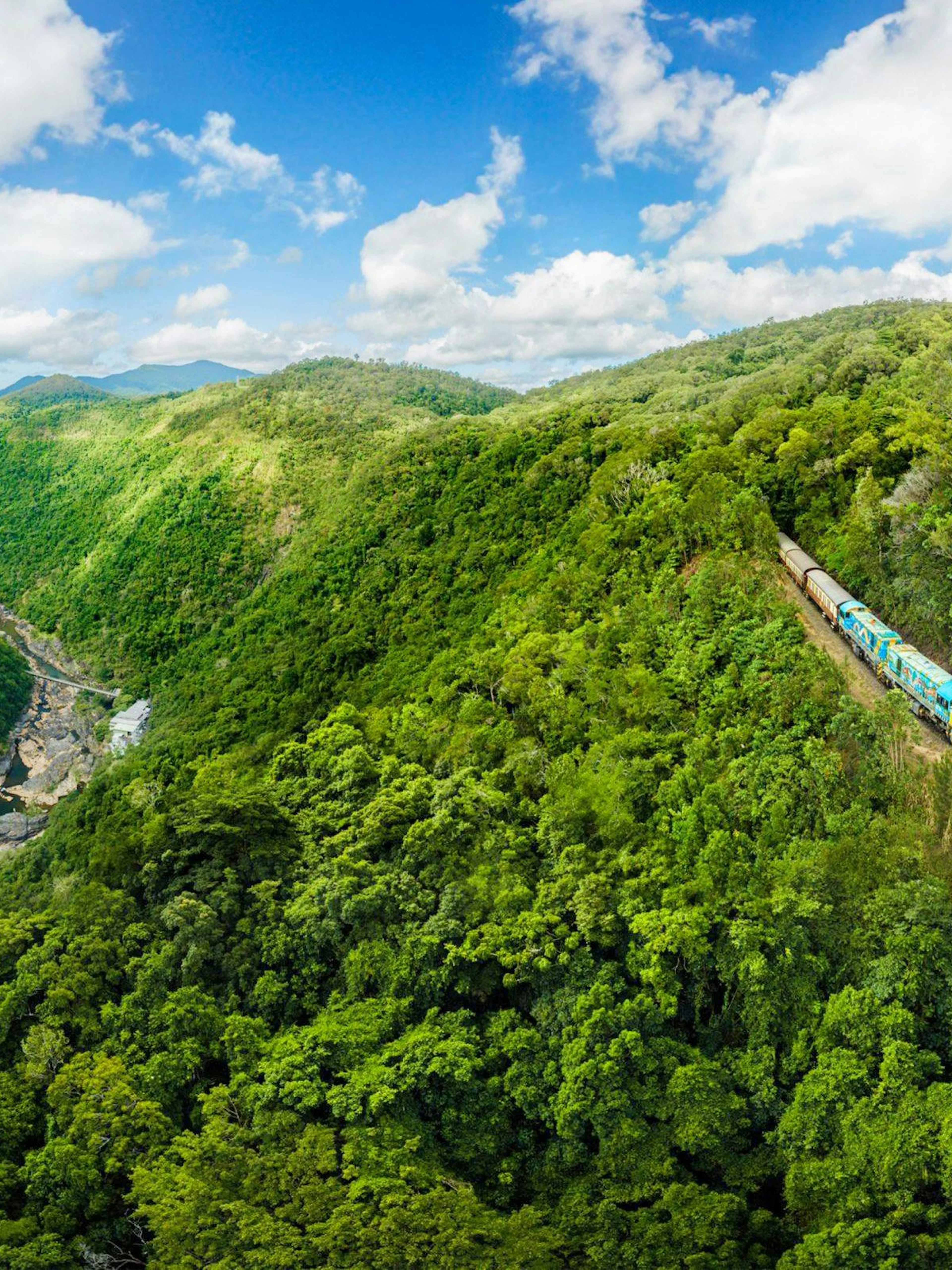 Kuranda Scenic Rail passing through lush rainforest in Queensland, Australia.