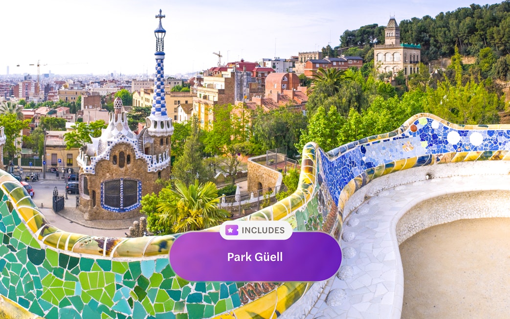 Park Güell's colorful mosaic terrace overlooking Barcelona cityscape.