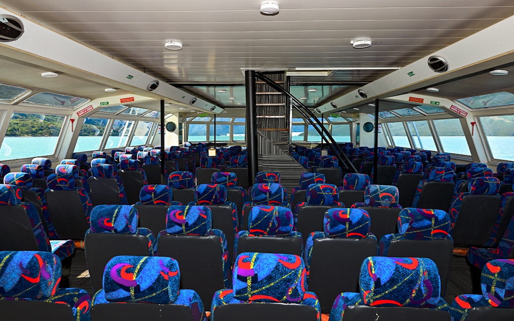 Interior seating of Perito Moreno Cruise with colorful patterned seats and large windows.