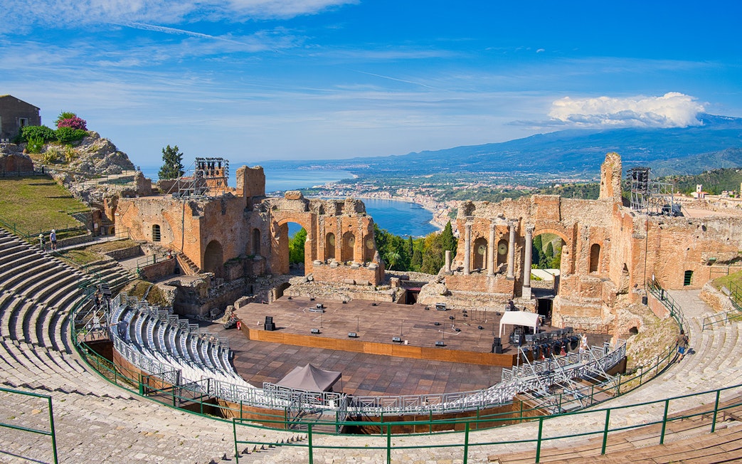 Panoramic view of ancient theatre of Taormina with coastline in background, Sicily.