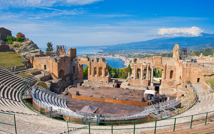 Panoramic view of ancient theatre of Taormina with coastline in background, Sicily.