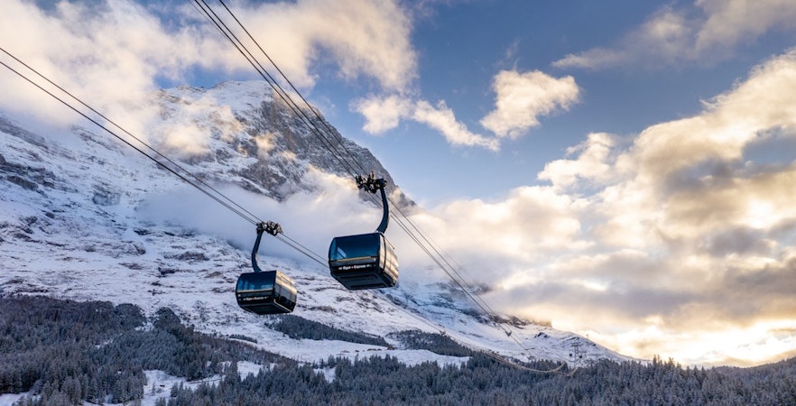 Cable cars ascending snowy mountains from Grindelwald to Jungfraujoch.