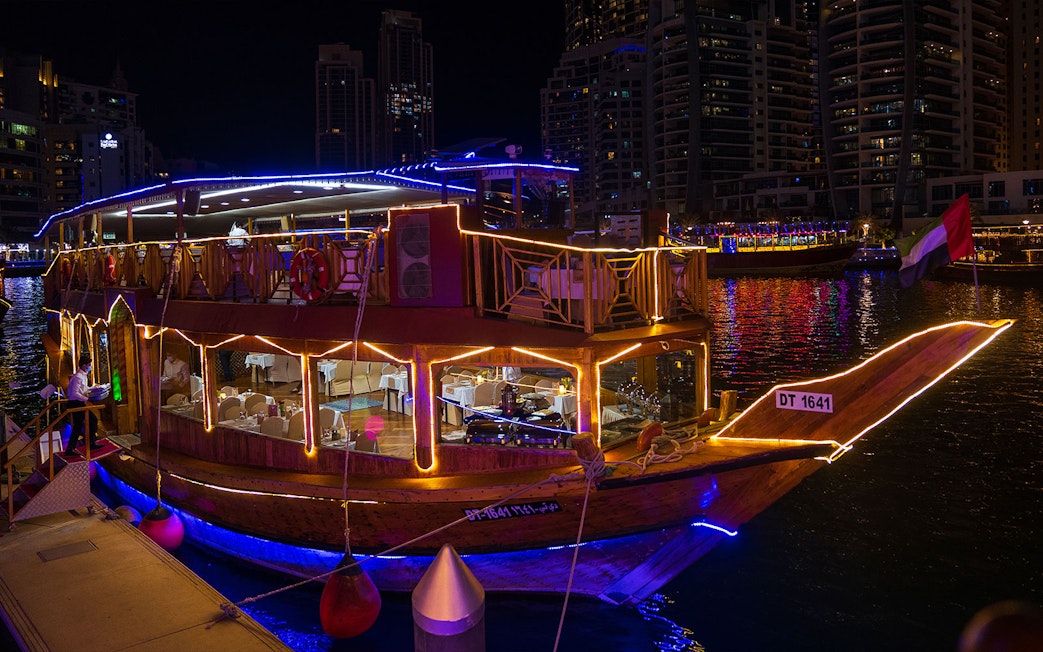 Dhow cruise with lights at night in Dubai Marina.