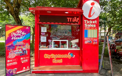 Ticket booth for Saigon Hop-on Hop-Off Sightseeing Tours in Hanoi park setting.