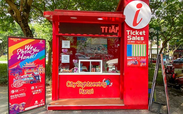 Ticket booth for Saigon Hop-on Hop-Off Sightseeing Tours in Hanoi park setting.