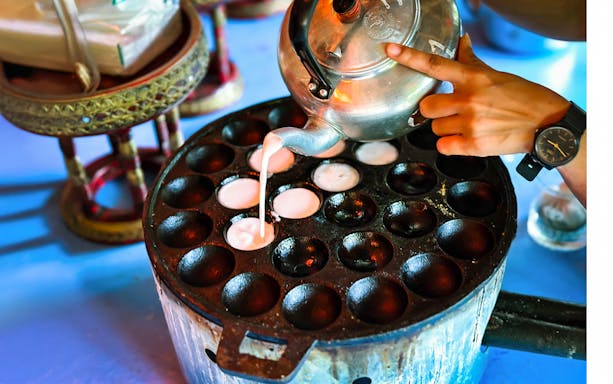 Pouring batter into a Thai kanom krok pan in Phuket.