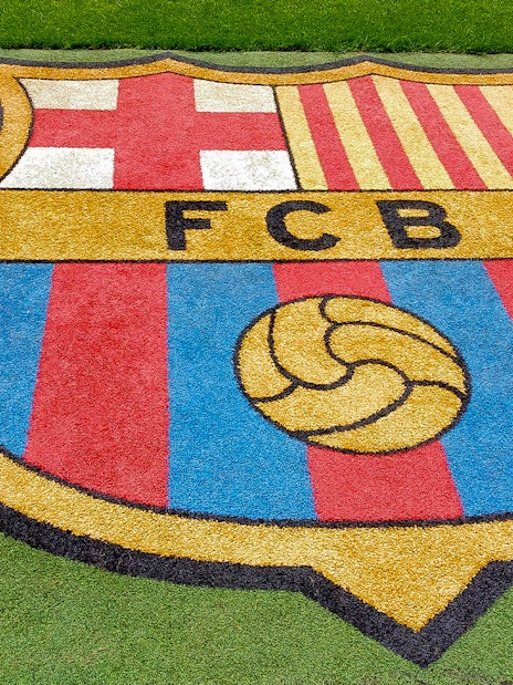 FC Barcelona crest on the grass at Camp Nou stadium.