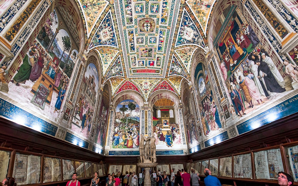 Frescoes and ornate ceiling in Piccolomini Library, Siena Cathedral, Italy.