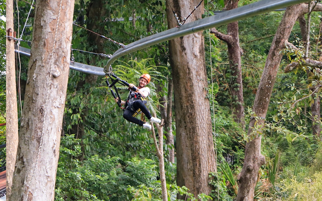 Man ziplining through lush forest in Phuket.