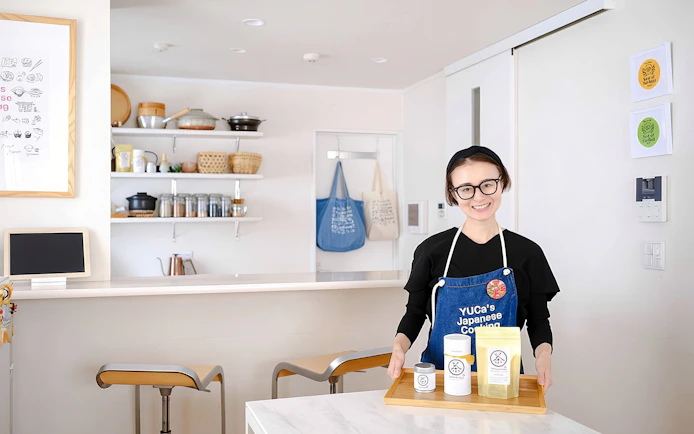 Chef in Tokyo kitchen with ingredients for ramen and gyoza cooking class.