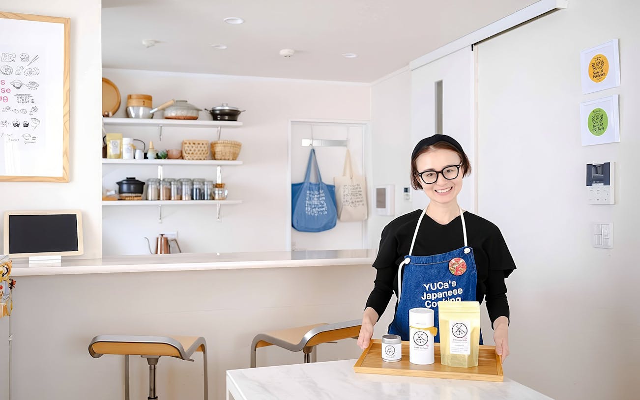 Chef in Tokyo kitchen with ingredients for ramen and gyoza cooking class.