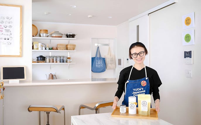 Chef in Tokyo kitchen with ingredients for ramen and gyoza cooking class.