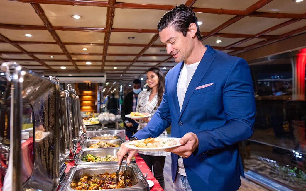 Guests serving themselves from a buffet on the Luxury Dhow Cruise.