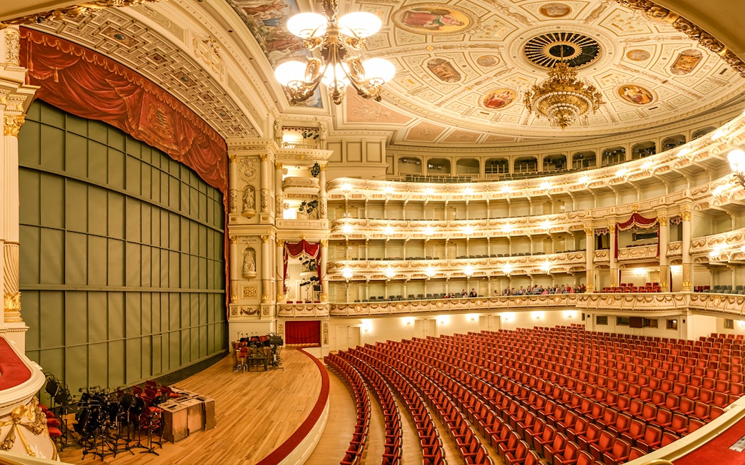 Semperoper Dresden auditorium with ornate ceiling and red seating.