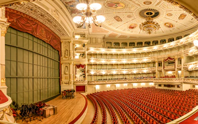 Semperoper Dresden auditorium with ornate ceiling and red seating.