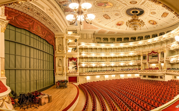 Semperoper Dresden auditorium with ornate ceiling and red seating.